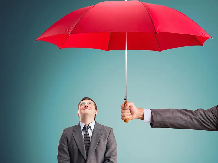 Um homem protegido por um guarda-chuva vermelho